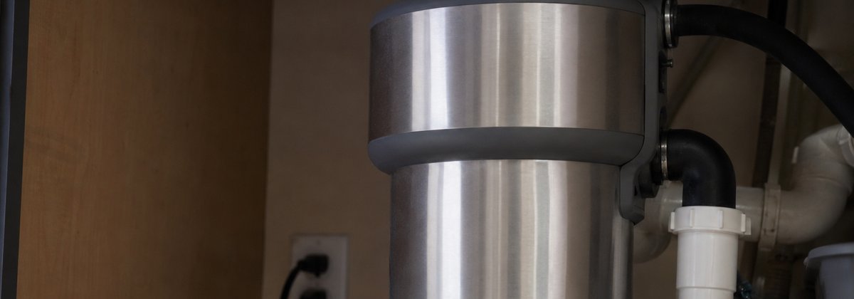 Easy Appliances Repair technician fixing a garbage disposal under a kitchen sink in a Denver home