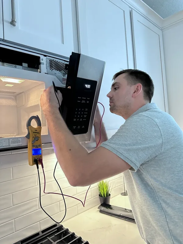 Victor testing a built-in microwave during a Denver microwave repair