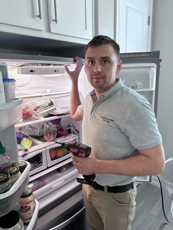 Victor repairing a refrigerator during a Highlands Ranch area service call