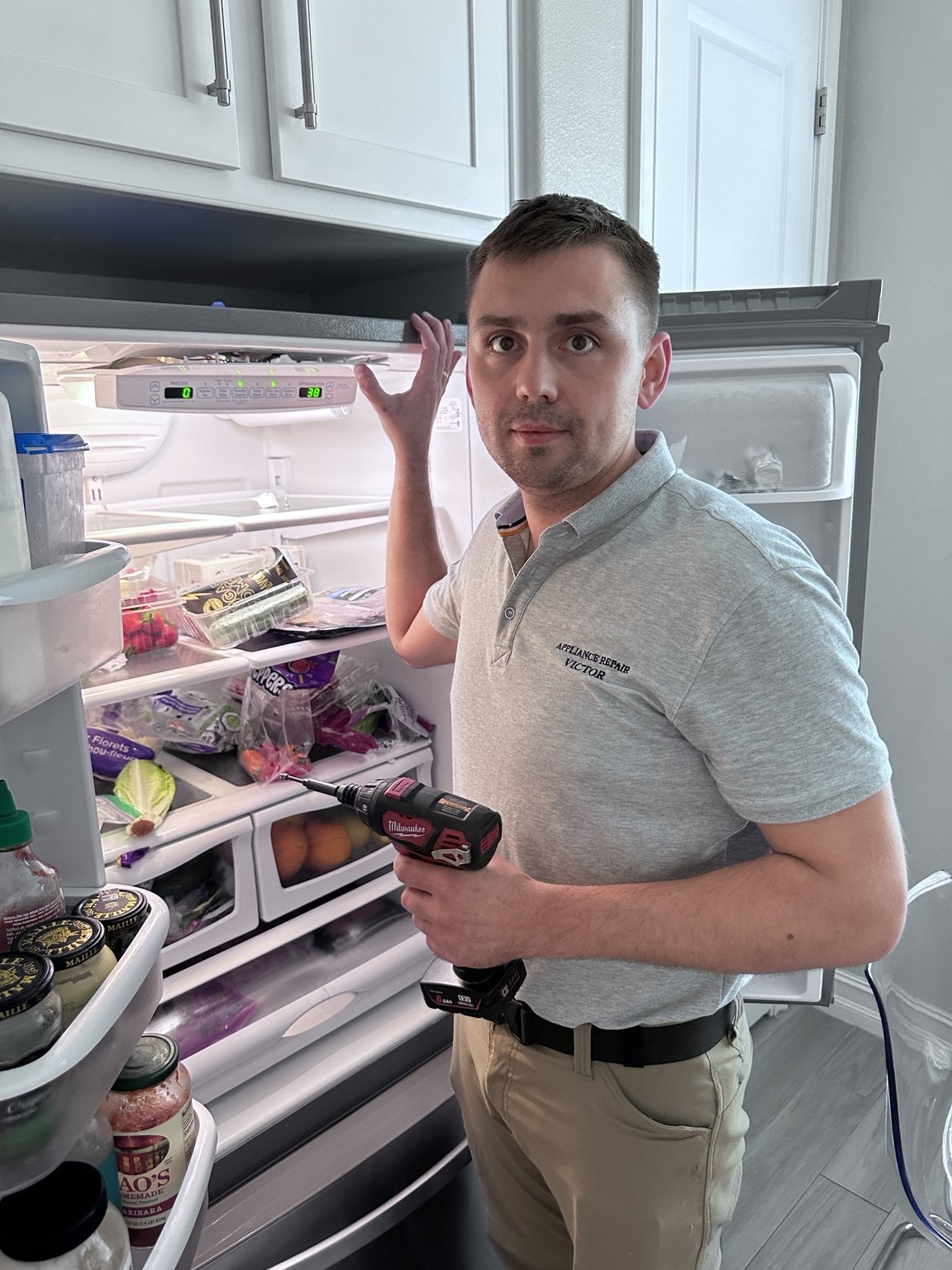 Victor diagnosing a refrigerator during an appliance repair call in the Parker service area